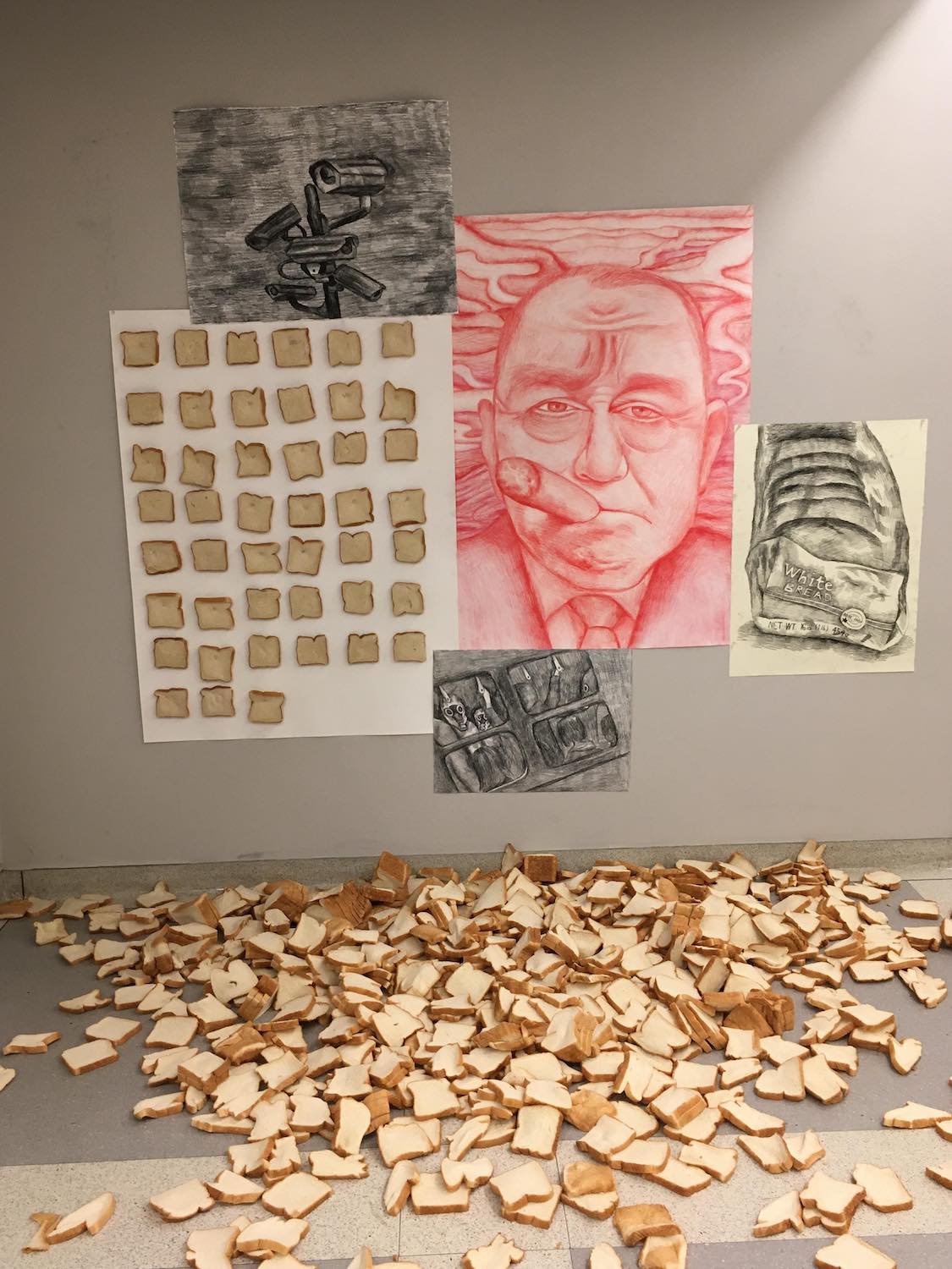 various artwork on a wall with sliced bread in a pile on the ground in front