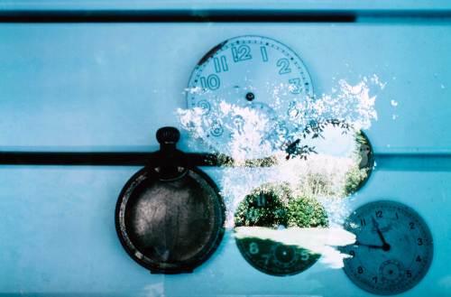 Garden scene super-imposed right of center on pocket watch and four watch faces.