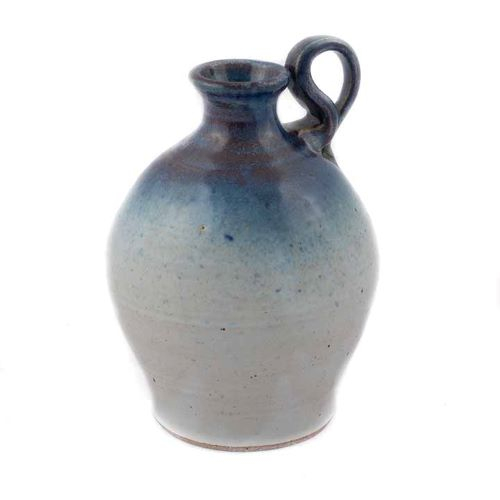 small jug with a predominantly white glaze and a cobalt blue shoulder, neck, and handle.