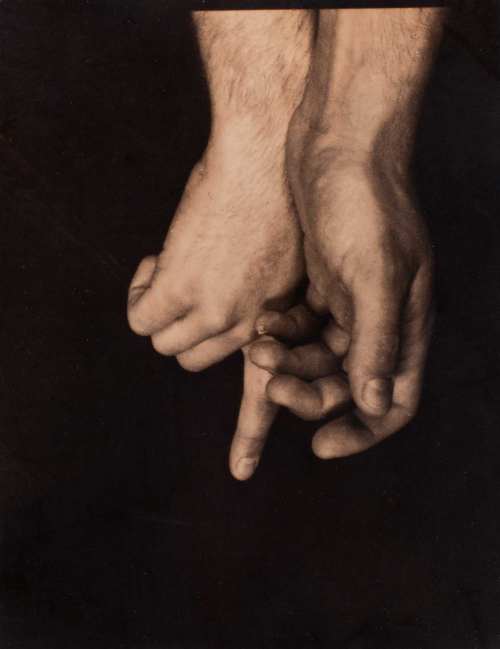 A tiny sepia-toned image showing two hands descending from the top of the frame.