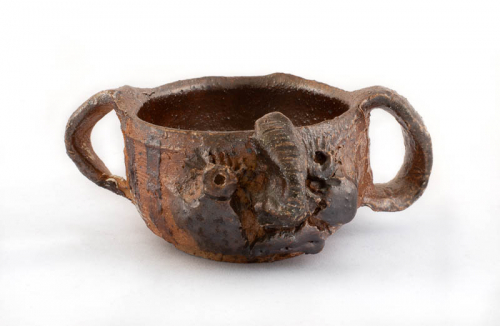 small brown "face jar" mug with handles, right and left, and an elephant's trunk. The artist has written "thanks" in the bowl.