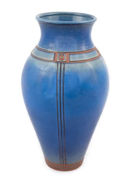 Large tall cobalt blue vase with horizontal and vertical linear incisions, where they meet are small squares with raised dots