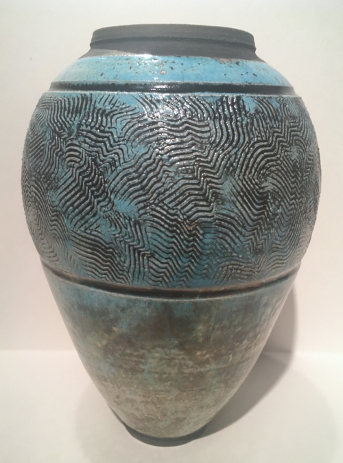An ovoid shaped vase with no neck that tapers to a smaller base and is decorated in a blue-green glaze