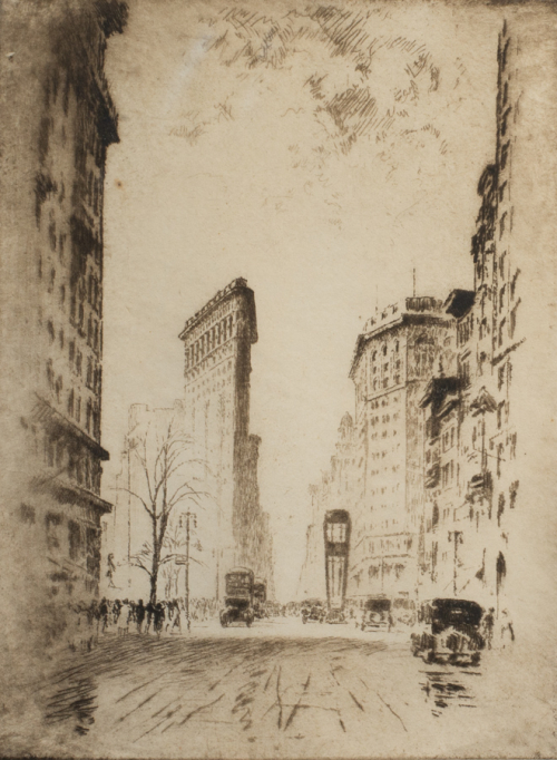 View of a city street, with old-fashioned cars and tall buildings