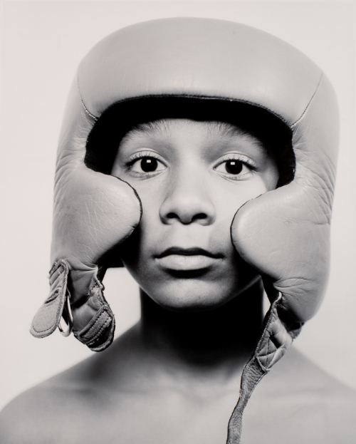 Head-and-shoulders portrait of a young African-American boy in a boxing helmet.