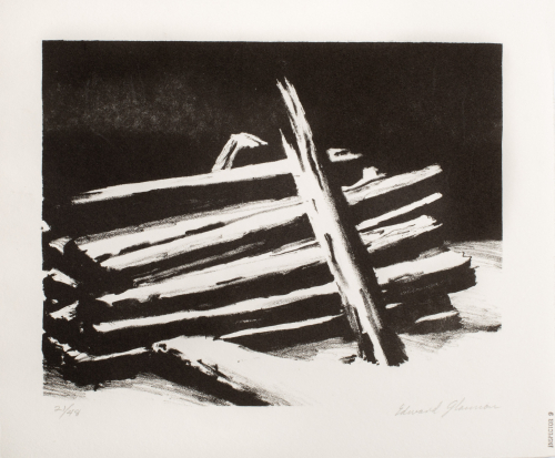 A nighttime image of a snow-covered pile of fencing or railroad ties.