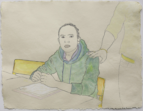 A young man wearing a green hoodie sits at a desk in front of loose-leaf papers