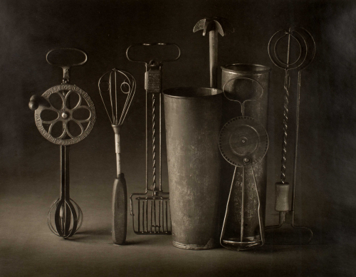 Still life with egg beaters standing vertically on grey background