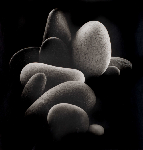 Still life with smooth, rounded stones on black background