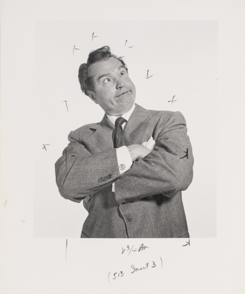 Man from waist and up; arms crossed in front of his chest, torso facing viewer Making a goofy face with crossed eyes