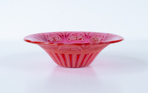 Wide-rimmed bowl in red and pink with strong radial lines and 8 flower shapes at the rim edges. 