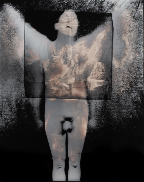 Large photograph of a nude man, posed angelically, with winglike shapes superimposed over his arms