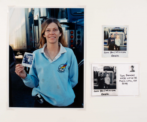 Two photographs and a postcard on a board. The dominant image is a female in a blue shirt in front of a truck holding a Polaroid