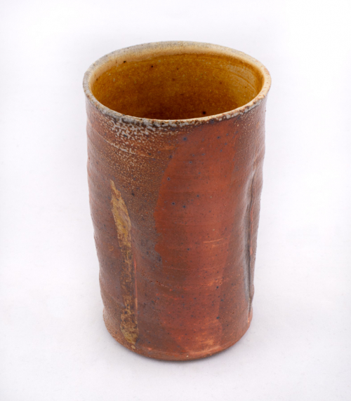A brown cylindrical cup with slight vertical indentations in three places.