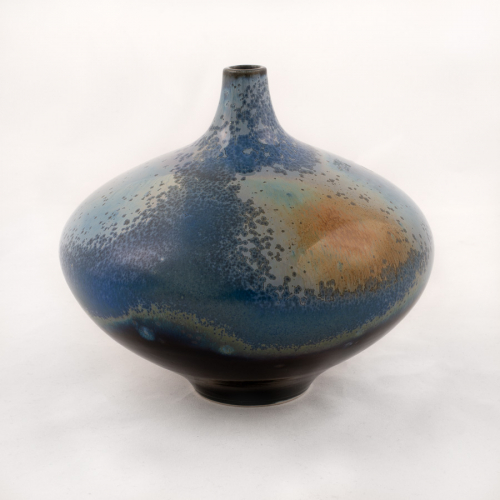 A large, wide, squat bud vase with a very narrow neck and mouth. Shiny glaze with mottled dark blue, light blue, and gold colors