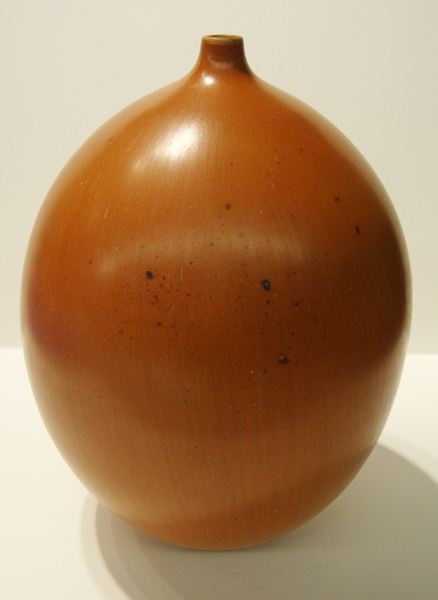 An orange ovoid vase with a narrow mouth