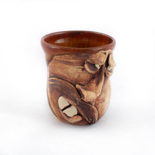 tiny brown face jug in the form of a cup. face has a prominent nose, teeth, and mustache skewed to the left
