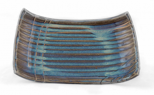 Brown and blue curved rectilinear tray with parallel marks along the length and only a few parallel marks perpendicular to them