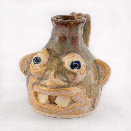 small face mug with handle, bulging eyes, and two prominent teeth