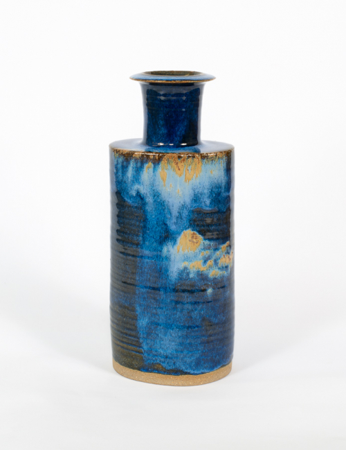 Tall, blue darkly marbled bottle with a fairly long neck and wide brim