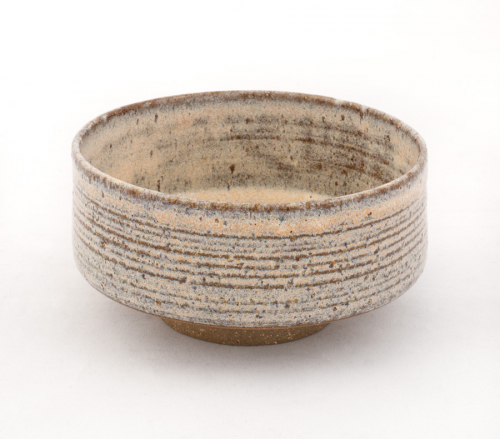 Light-colored bowl with tall sides and a small base, horizontal gray markings in its sides