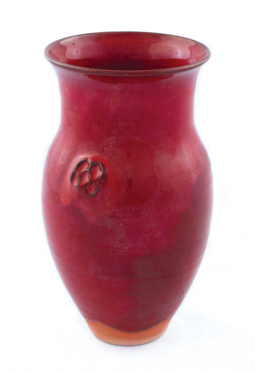 A bright red amphora-shaped vase with wide mouth and only an indication of handles.