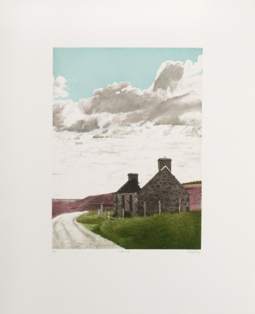 Ruined dark-grey brick building with roof gone in country scene: green grass, gravel road, blue sky with clouds 