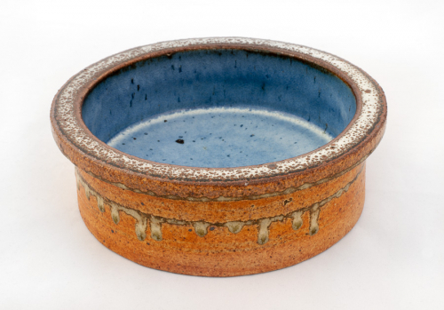 Bowl with tall edges and a rim; "drips" of light glaze around the middle of the edge