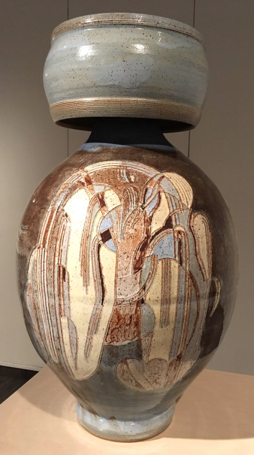A large ovoid vase with cylindrical cap, glazed in browns, whites, and blues with abstract markiings