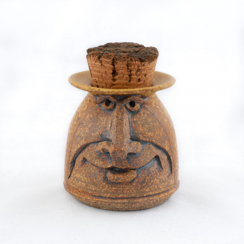 small matte beige glazed face jug with smooth symmetrical features and a cork stopper