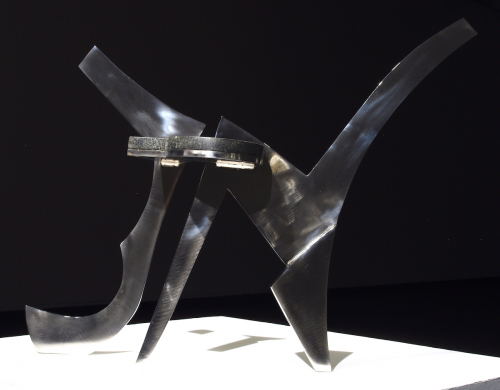 A non-representational tripod sculpture in stainless steel