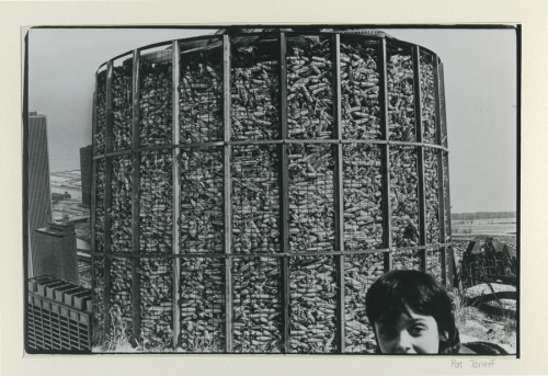 Black and white photo montage of a large corn bin, skyscrapers and a child's face