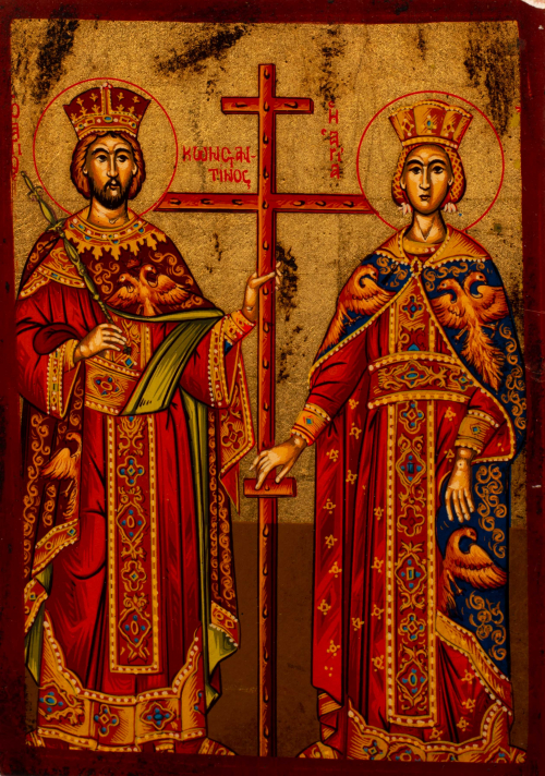 Greek icon depicting an ornately dressed king (left) and queen (right) supporting a cross.