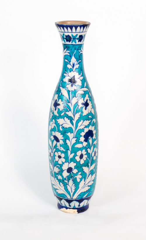 Tall, slender vase with very decorative flowers and leaves on its surface and patterns on its base and at the top of its rim