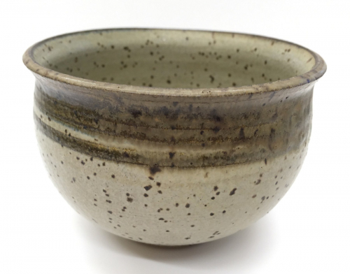 A rice bowl form, beige with dark brown speckles, and a dark band at the rim.