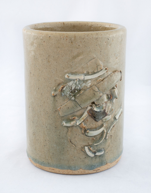 Cylindrical vase with relief carving and light glaze.