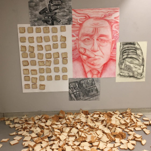 various artwork on a wall with sliced bread in a pile on the ground in front